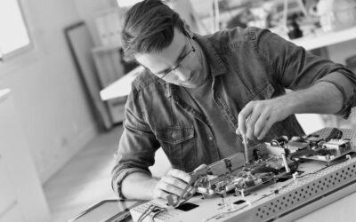 Un homme en train de réparer une télévision