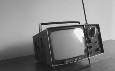 Une télévision ancienne est posé sur un meuble.